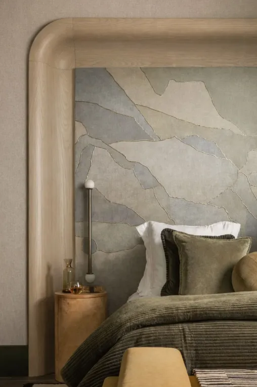 Rounded oak bed frame with textured plaster art panel and olive corduroy bedding   bespoke detail