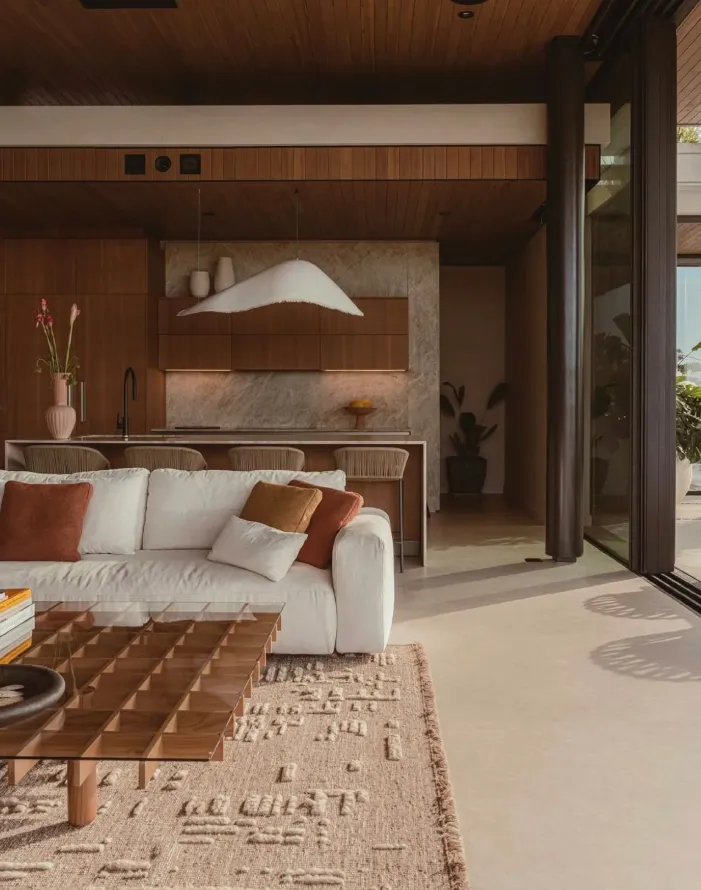 Warm minimalist apartment interior design Ras Al Khaimah UAE   timber ceiling cream sofa terracotta cushions