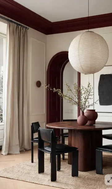 Dining room with burgundy trim paper lantern and walnut table   warm residential dining