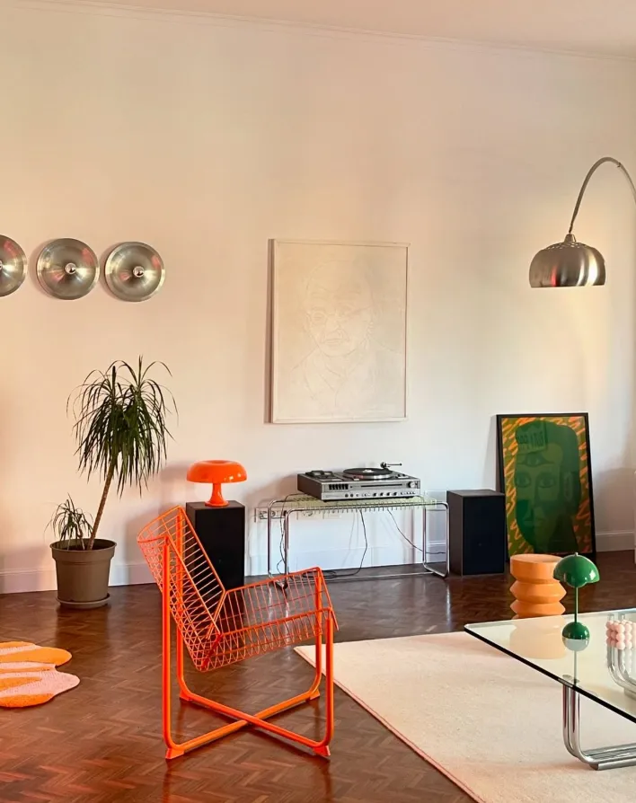 Budapest apartment interior   orange wire chair arc lamp parquet floor and warm lamplight